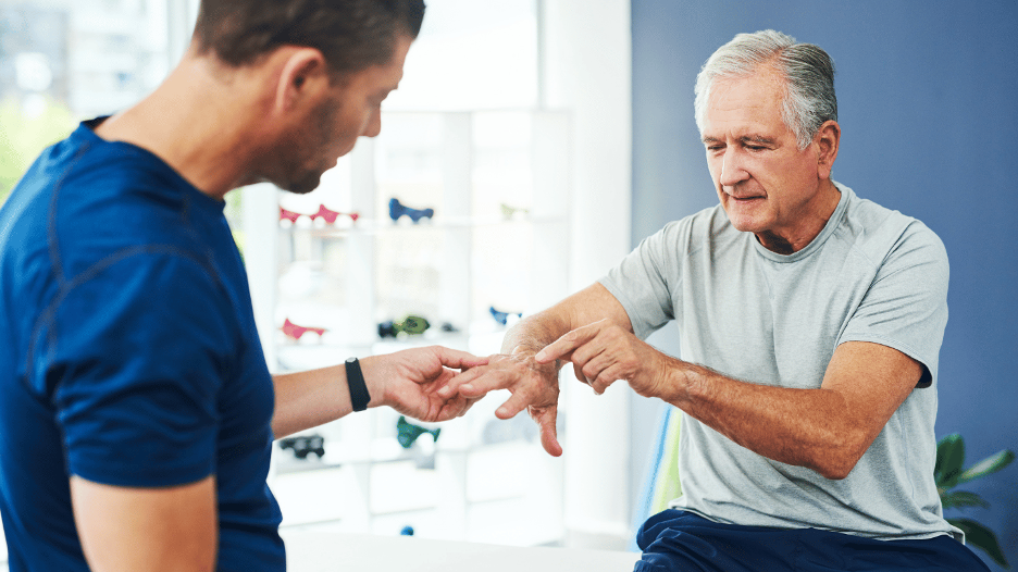 An older man consults with a Summit Health physical therapist about preventing arthritis in his hands, focusing on pain management and improving joint function