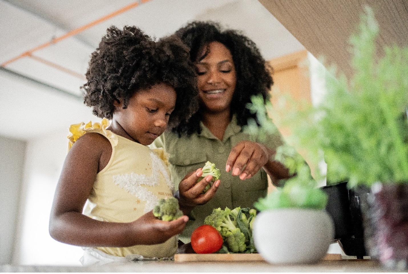 Mom and daughter preparing a healthy meal together in the kitchen. 