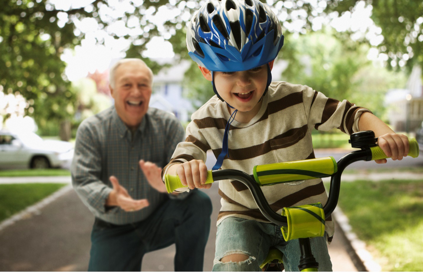 Grandfather cheering on his grandchild learning to ride a bike, symbolizing guidance and support for navigating 2025 Medicare changes.