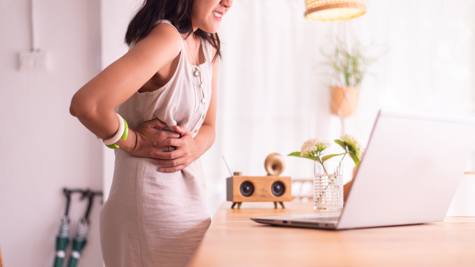 A woman grasping her side, experiencing appendicitis pain in her abdomen