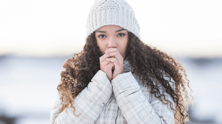 Woman experiencing Reynaud’s phenomenon outside in the cold weather