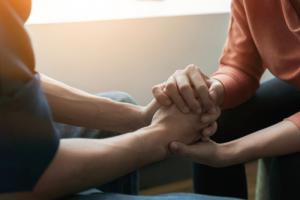 Person easing someone's stress by holding their hands