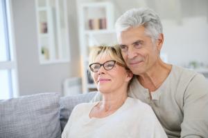 Man and woman in glasses embracing after cataract surgery