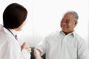 Geriatrician speaking to an elderly patient about medical treatment