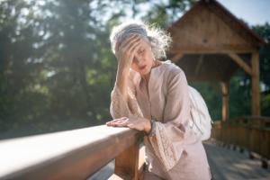 Woman holding her forehead after suffering a ministroke outside