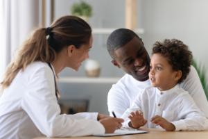 A pediatrician interacting with a young child diagnosed with sickle cell anemia