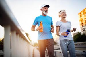 Elderly couple with water bottles practicing fall prevention strategies while running