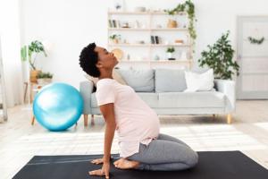 Pregnant woman practicing pain management by doing yoga