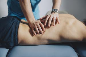 Closeup of a massage therapist working on a patient's back