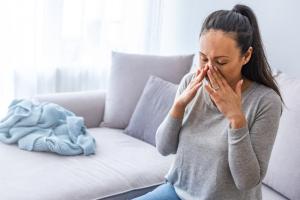 Woman gripping the sides of her nose after experiencing sinusitis symptoms