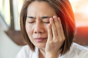 woman massaging temples after experiencing Bell's palsy symptoms