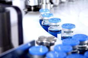 Closeup of medication and biosimilar vials on assembly line