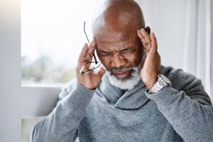 Man touching his temples after experiencing migraine symptoms