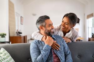 Man and woman embracing and smiling on a couch