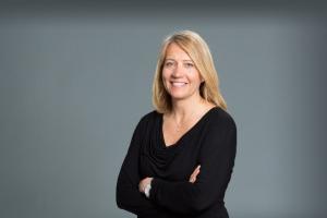 portrait of nurse practitioner Jacquelyn Plick crossing her arms and smiling