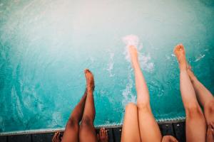 Three swimmers sitting on the side of a pool