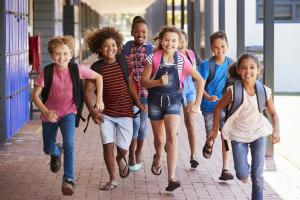 a group of school children running and laughing