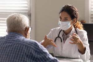 Provider explaining care to an elderly male patient