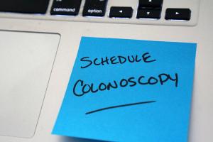 Sticky note on computer that says schedule colonoscopy