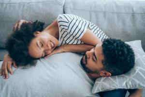 Man suffering from erectile dysfunction laying down with woman on a couch