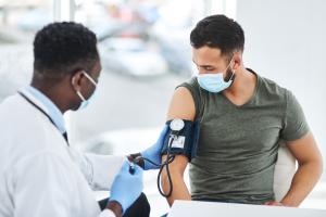 Medical professional monitoring a patient's blood pressure for signs of hypertension