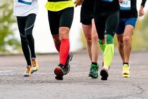 Joggers using colorful compression socks to help with blood flow