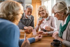 Group of older adults playing cards to reduce memory loss symptoms 