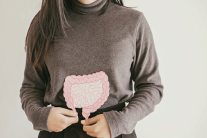 Close-up of a woman holding a diagram of the human intestines, symbolizing improved gut health and digestive wellness