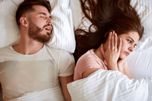 Man snoring and disturbing his partner