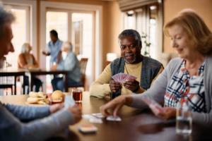 Medicare patients playing cards together at a table.