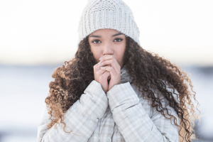 Woman experiencing Reynaud’s phenomenon outside in the cold weather